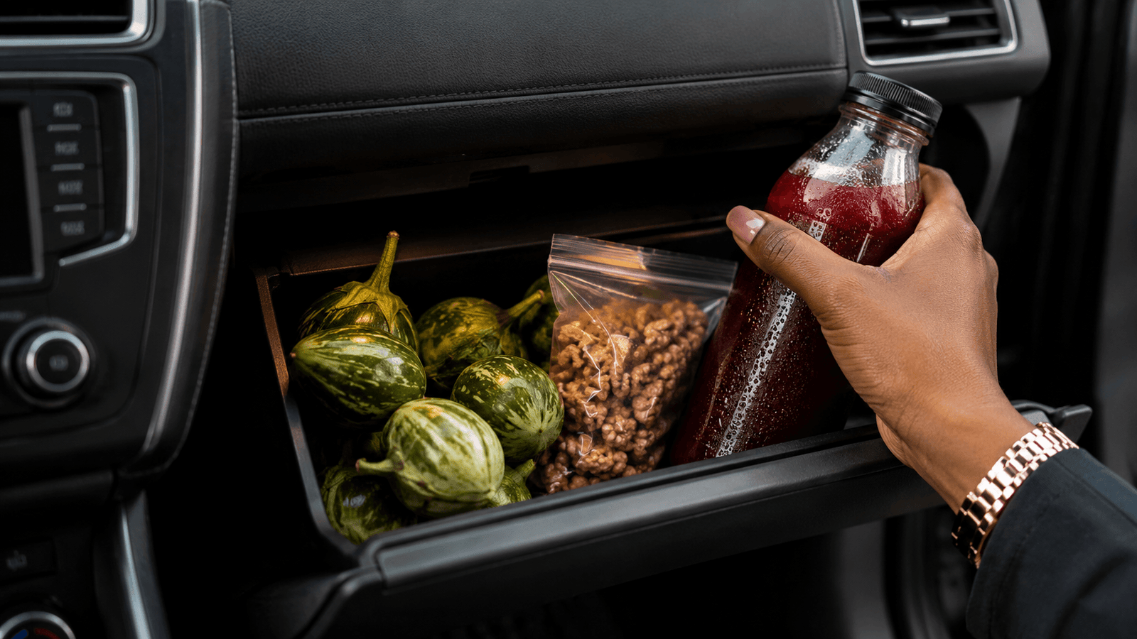 A person reaching into a car glove compartment for garden eggs, walnuts, and Zobo—the perfect healthy lifestyle tips for office workers stuck in Lagos traffic
